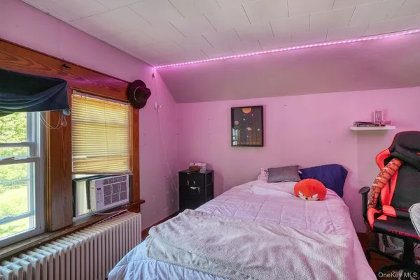 a bedroom with a bed and a large window