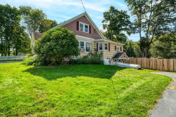 a front view of a house with a yard and trees