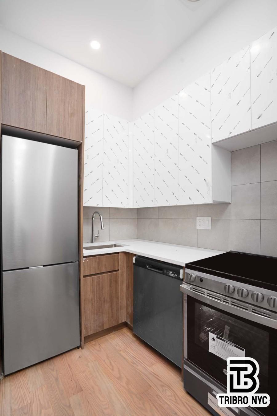 62-15 Catalpa Avenue, Unit 3A Queens, NY 11385 - Photo 3 of 9 a kitchen with granite countertop a stove and a refrigerator