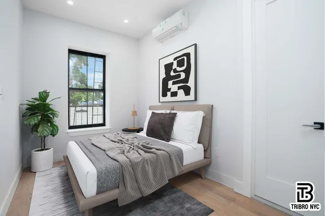 a bedroom with bed and a potted plant