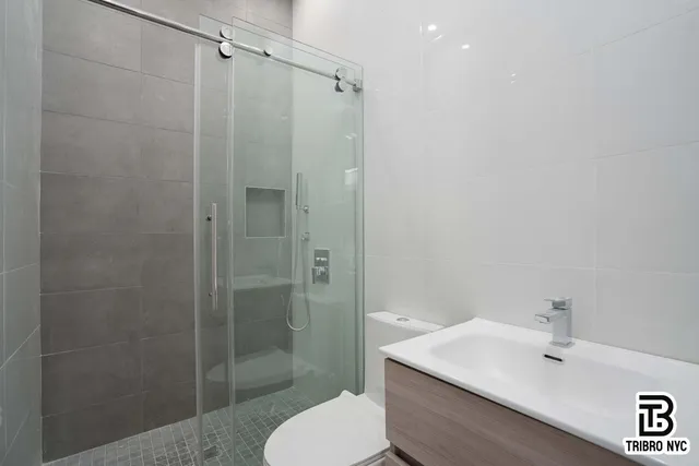 a bathroom with a shower a toilet and sink