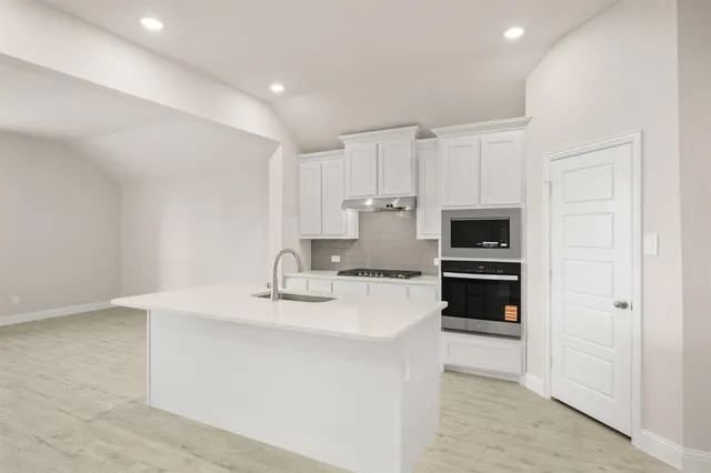 a kitchen with kitchen island a sink stainless steel appliances and cabinets