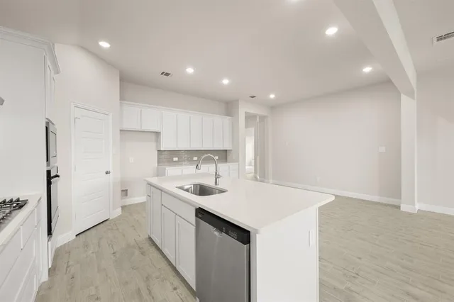 a kitchen with white cabinets and stainless steel appliances