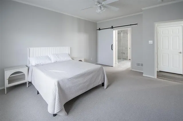 a spacious bedroom with a bed and a chandelier