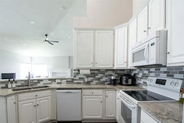 a kitchen with cabinets appliances a sink and a counter top space