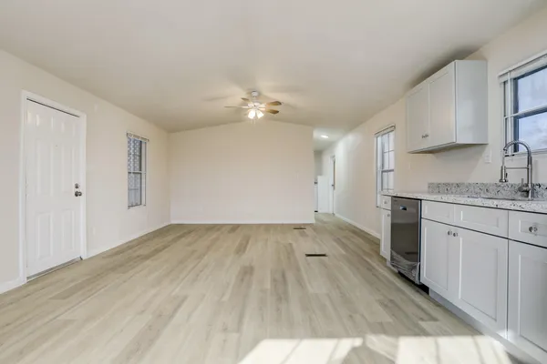 wooden floor in an empty room with a kitchen