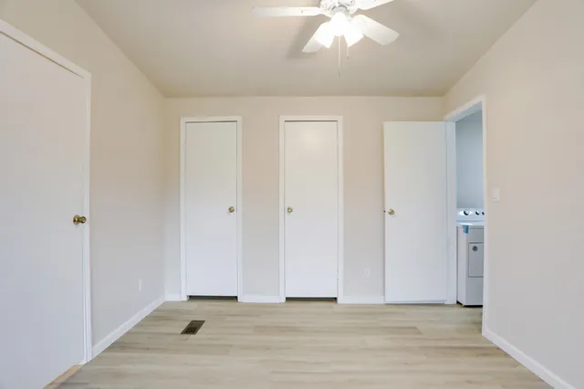 a view of an empty room with wooden floor