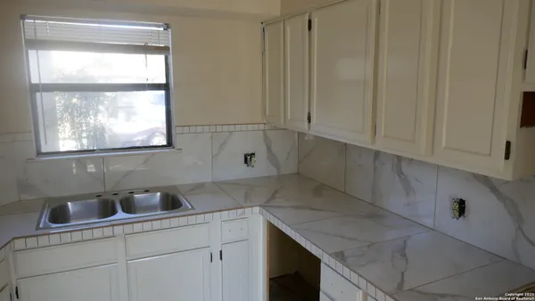 a kitchen with a sink cabinets and window