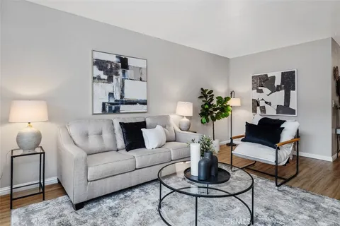 a living room with furniture a rug and a lamp