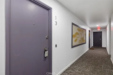 a view of hallway with wall paintings and a wooden floor