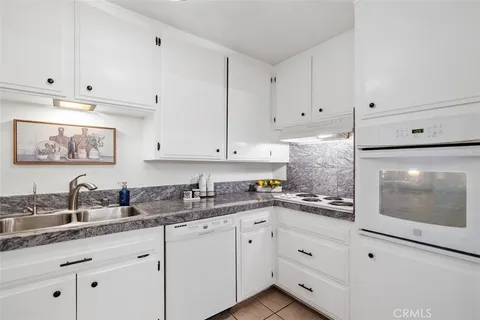 a kitchen with white cabinets and white appliances