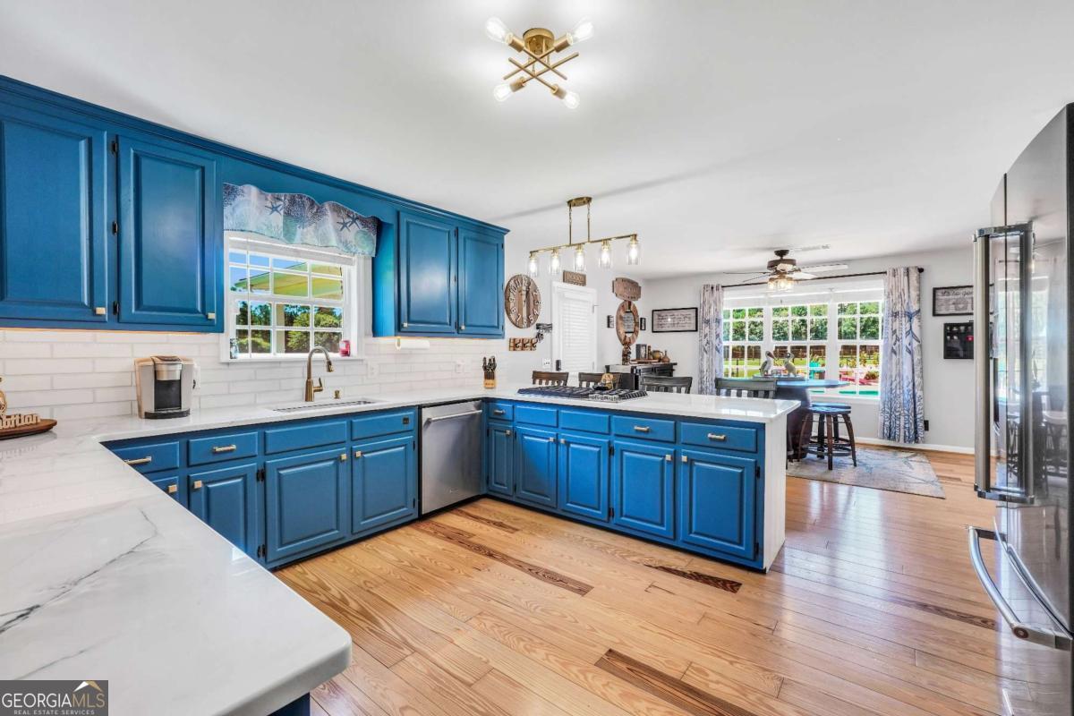 159 County Line Road Locust Grove, GA 30248 - Photo 18 of 100 a kitchen with stainless steel appliances granite countertop a sink dishwasher stove and wooden cabinets with wooden floor