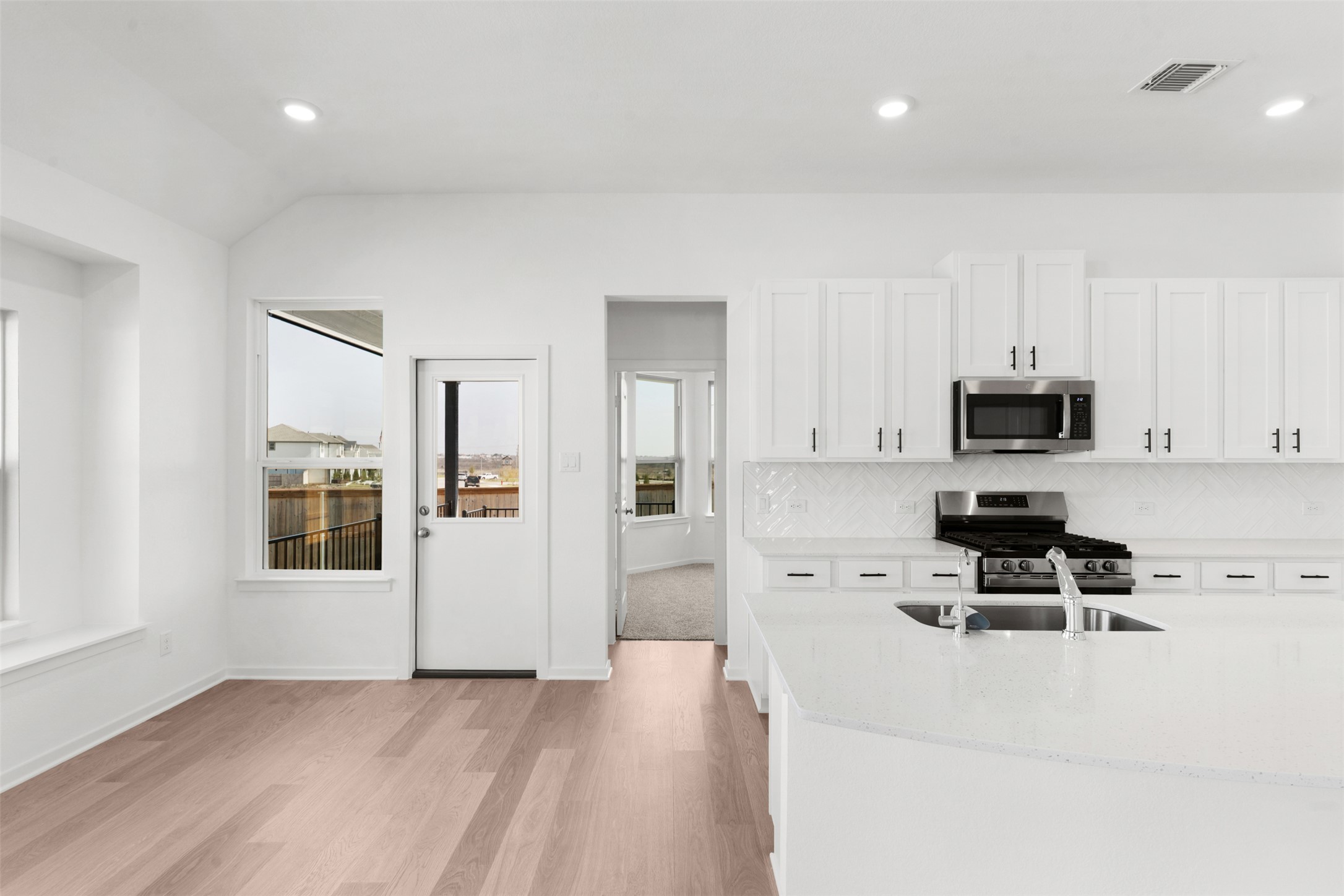 25601 Flora Bella Lane Elgin, TX 78621 - Photo 21 of 27 a kitchen with stainless steel appliances a stove top oven a sink a refrigerator and white cabinets
