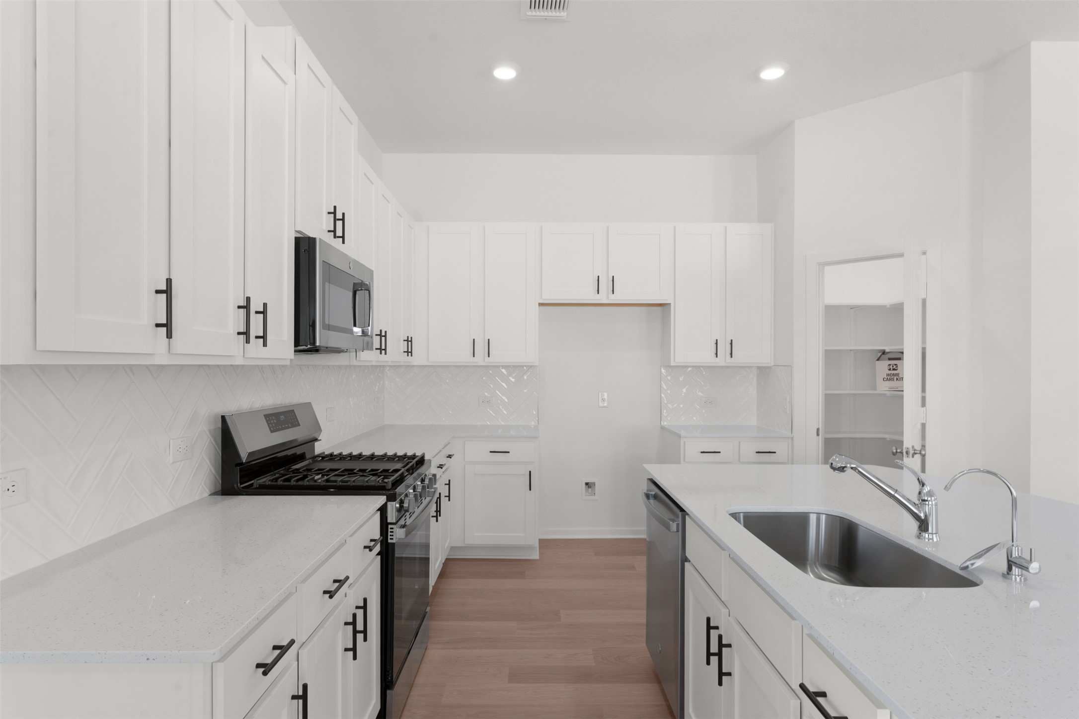 25601 Flora Bella Lane Elgin, TX 78621 - Photo 15 of 27 a kitchen with white cabinets a sink a stove and a refrigerator with white cabinets