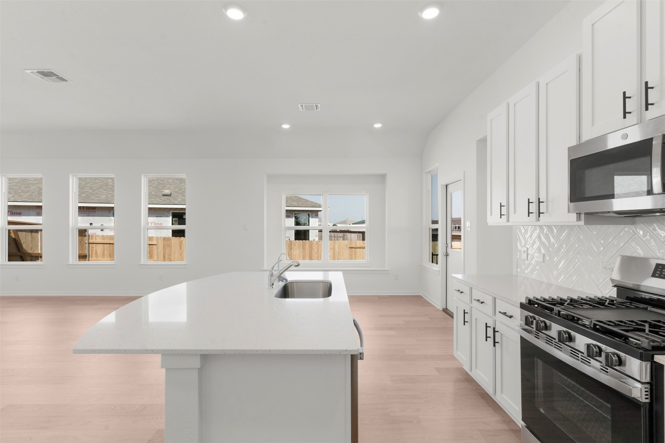 25601 Flora Bella Lane Elgin, TX 78621 - Photo 16 of 27 a kitchen with stainless steel appliances a stove a sink a microwave a refrigerator and cabinets