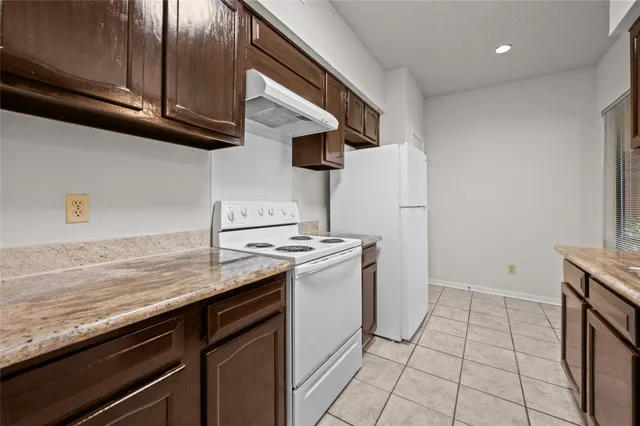 a kitchen that has a sink a stove and a refrigerator