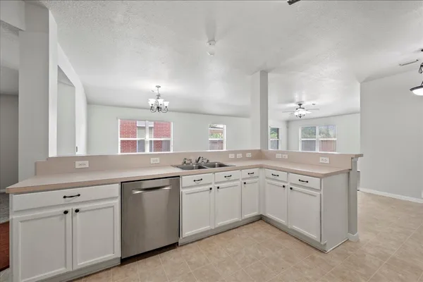 a kitchen with cabinets a sink and white appliances