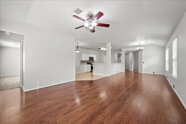 a view of a dining room with furniture a chandelier and wooden floor