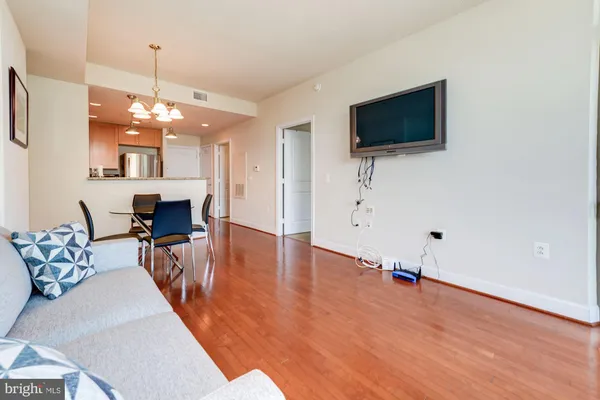 a living room with furniture a flat screen tv and kitchen view