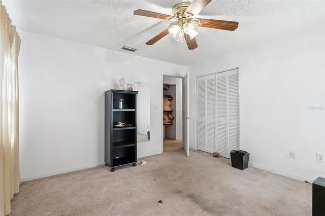 an empty room with closet and windows