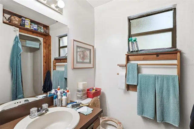 a bathroom with a sink mirror and a window