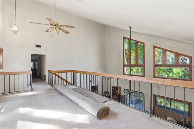 a view of a porch with wooden floor windows and a chandelier fan