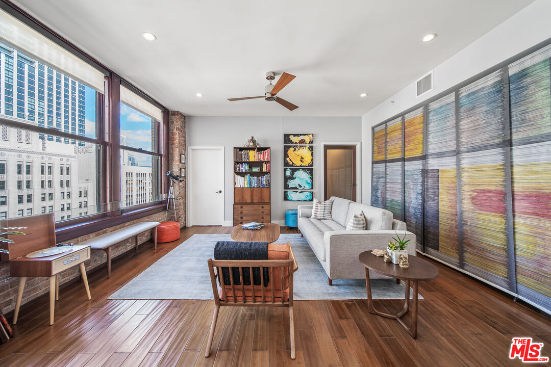 460 South Spring Street, Unit 1205 Los Angeles, CA 90013 - Photo 11 of 37 a living room with furniture floor to ceiling window and wooden floor