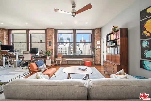 a living room with furniture kitchen view and a large window