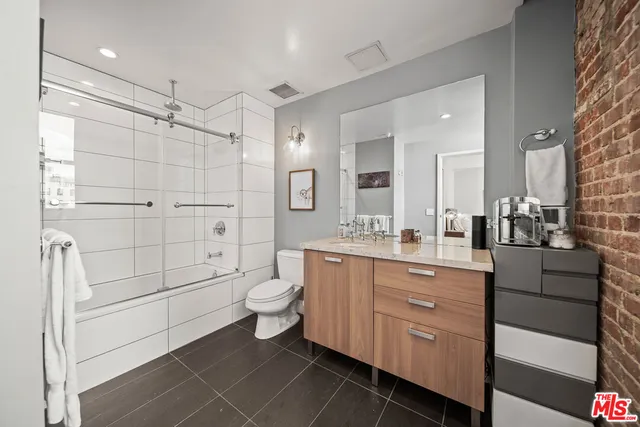 a bathroom with a toilet a sink and a large mirror