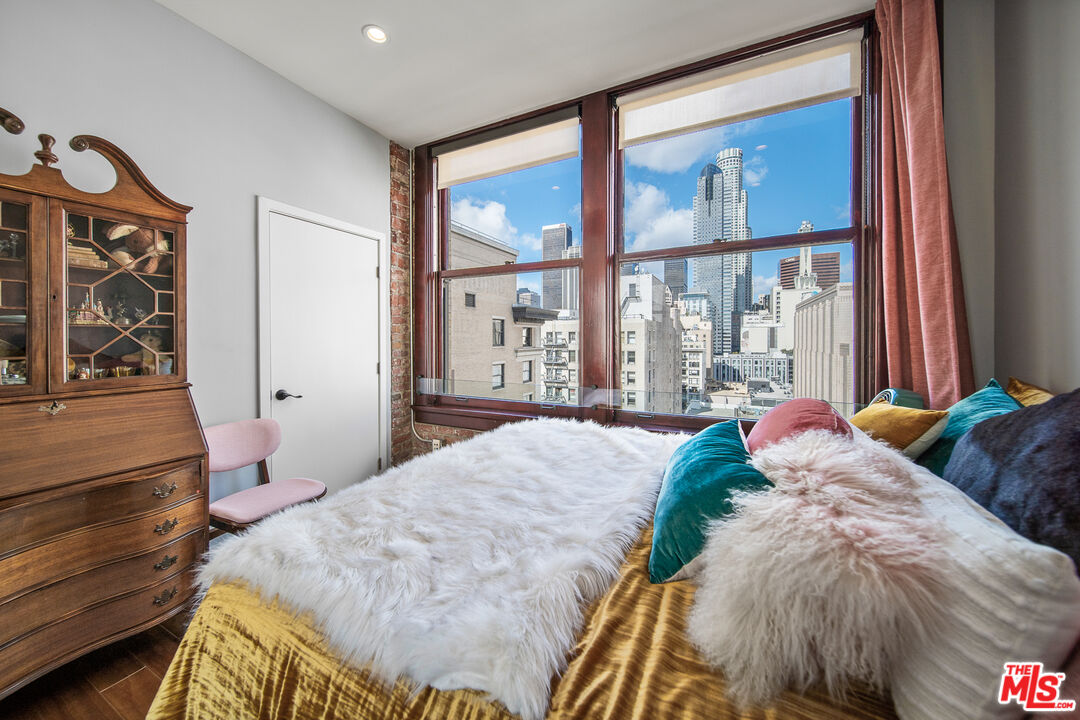 460 South Spring Street, Unit 1205 Los Angeles, CA 90013 - Photo 21 of 37 a bed sitting in a bedroom next to a window