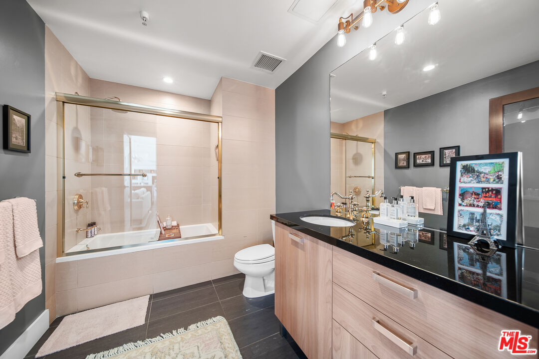 460 South Spring Street, Unit 1205 Los Angeles, CA 90013 - Photo 22 of 37 a bathroom with a double vanity sink toilet and shower