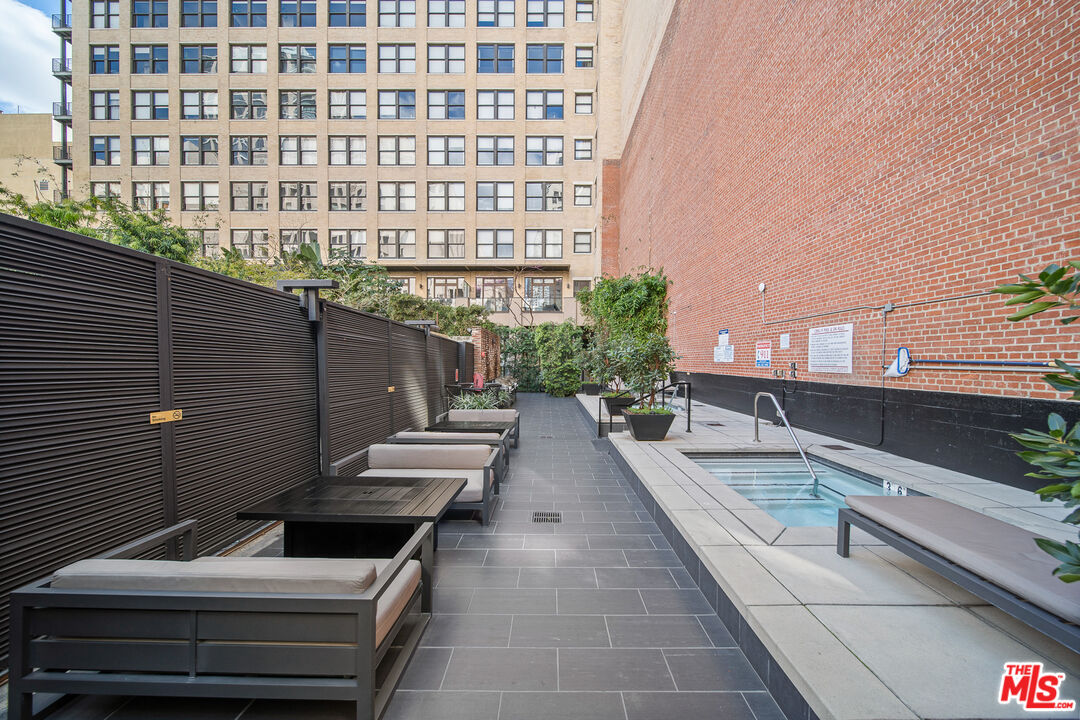 460 South Spring Street, Unit 1205 Los Angeles, CA 90013 - Photo 24 of 37 a view of a balcony with chairs and wooden fence