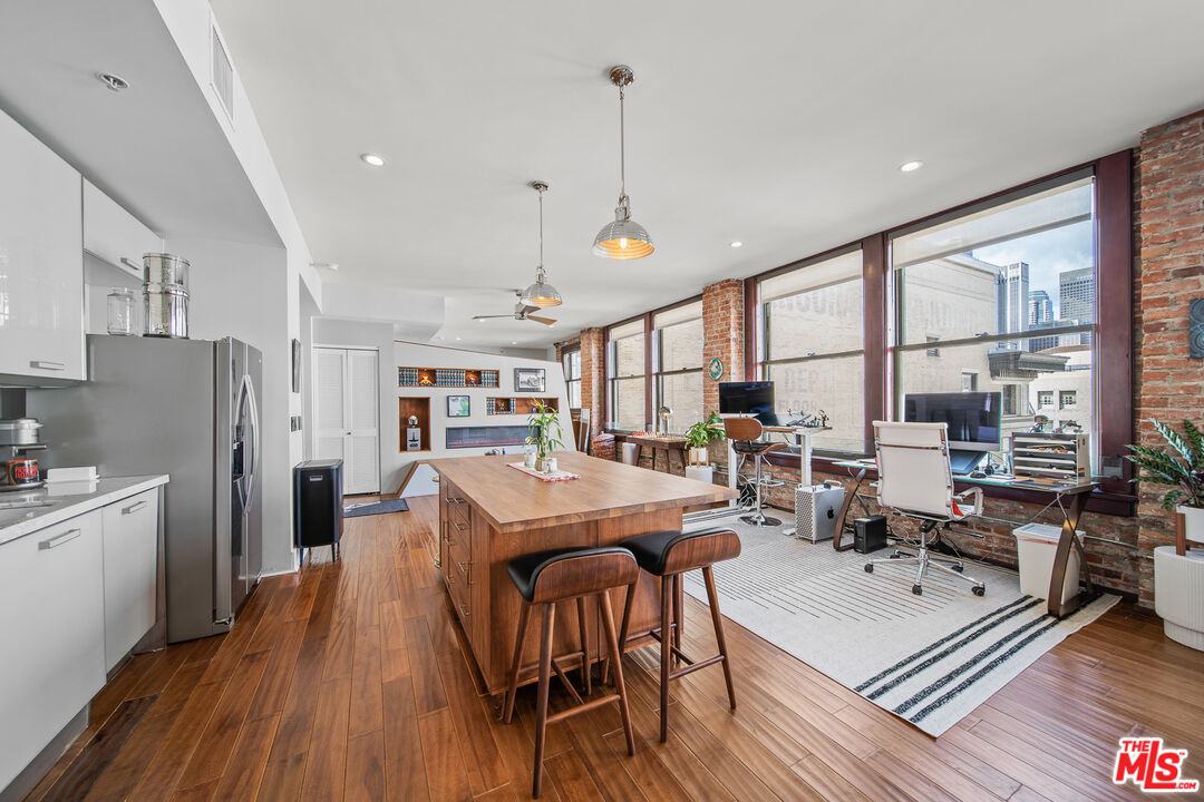 460 South Spring Street, Unit 1205 Los Angeles, CA 90013 - Photo 8 of 37 a living room with stainless steel appliances granite countertop furniture wooden floor and a view of kitchen