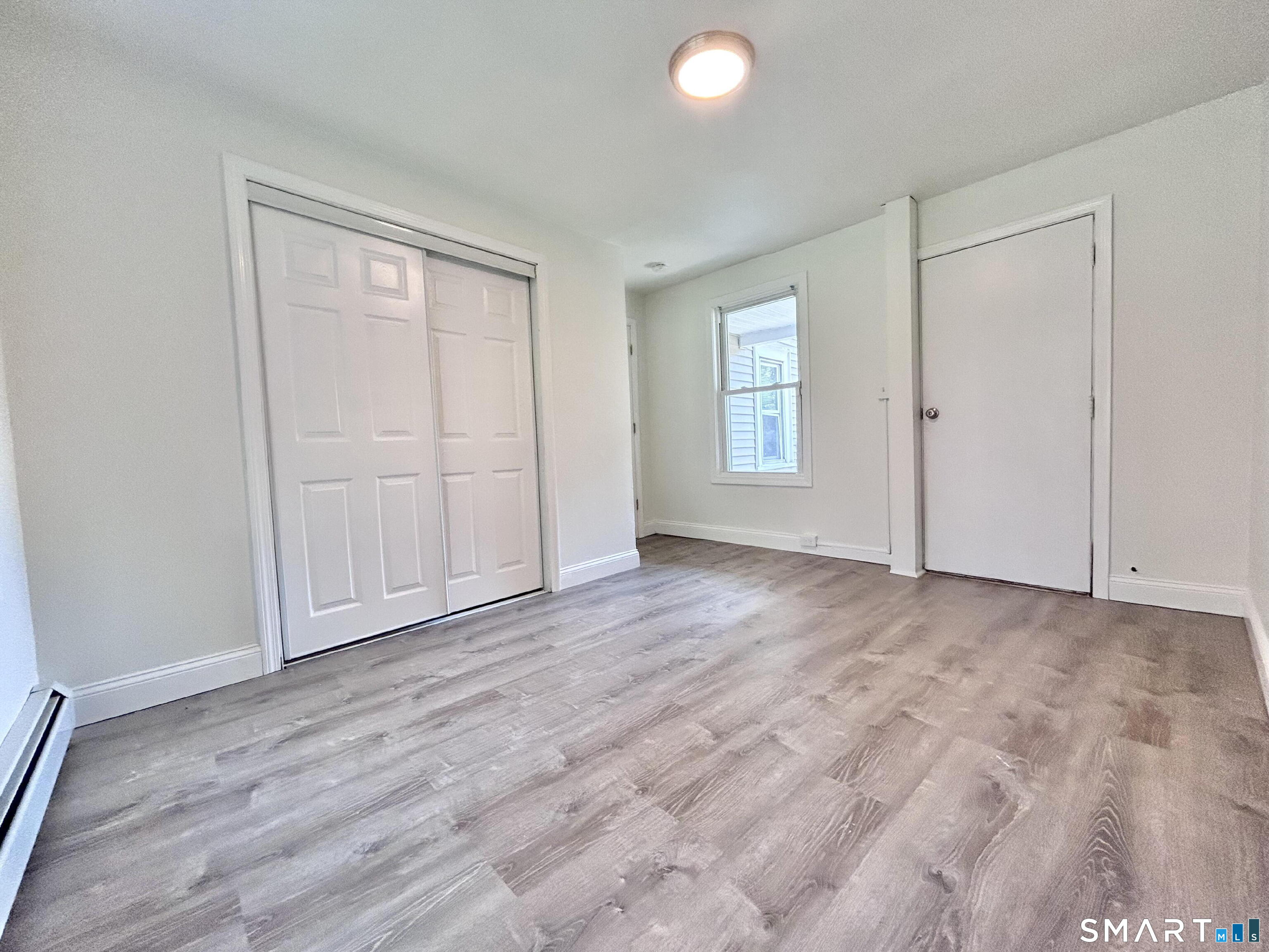 54 Roath Street Norwich, CT 06360 - Photo 11 of 16 a view of empty room with wooden floor and fan