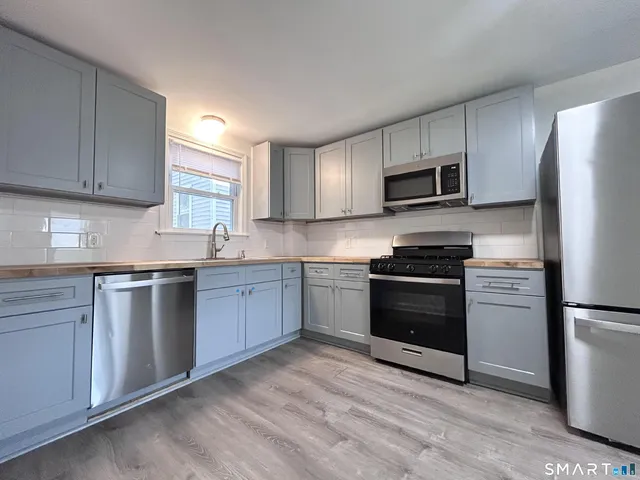 a kitchen with granite countertop a refrigerator stove and microwave
