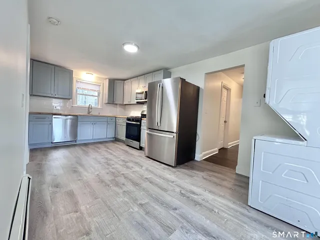 a kitchen with stainless steel appliances granite countertop a refrigerator and a stove top oven