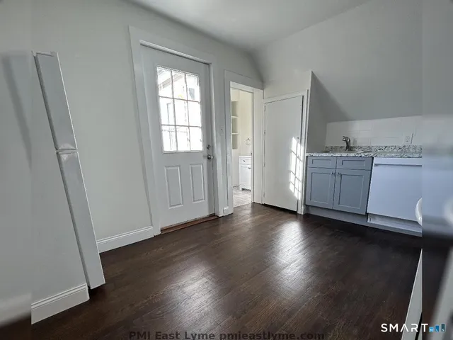 a view of a kitchen with wooden floor and electronic appliances