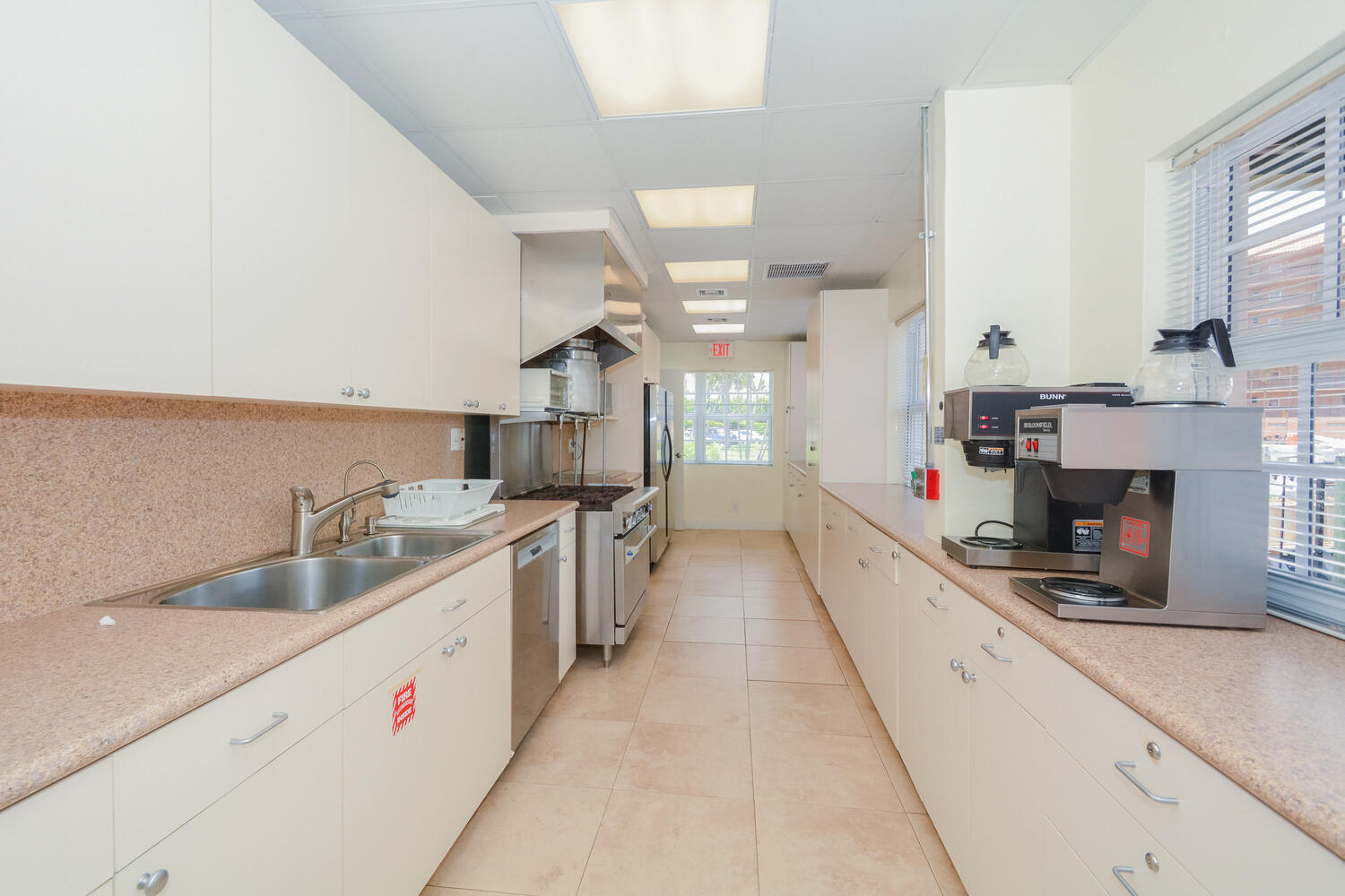 2871 North Ocean Boulevard, Unit F429 Boca Raton, FL 33431 - Photo 32 of 38 a large white kitchen with cabinets