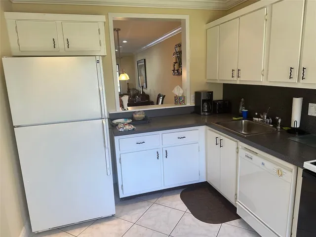 a kitchen with white cabinets and refrigerator