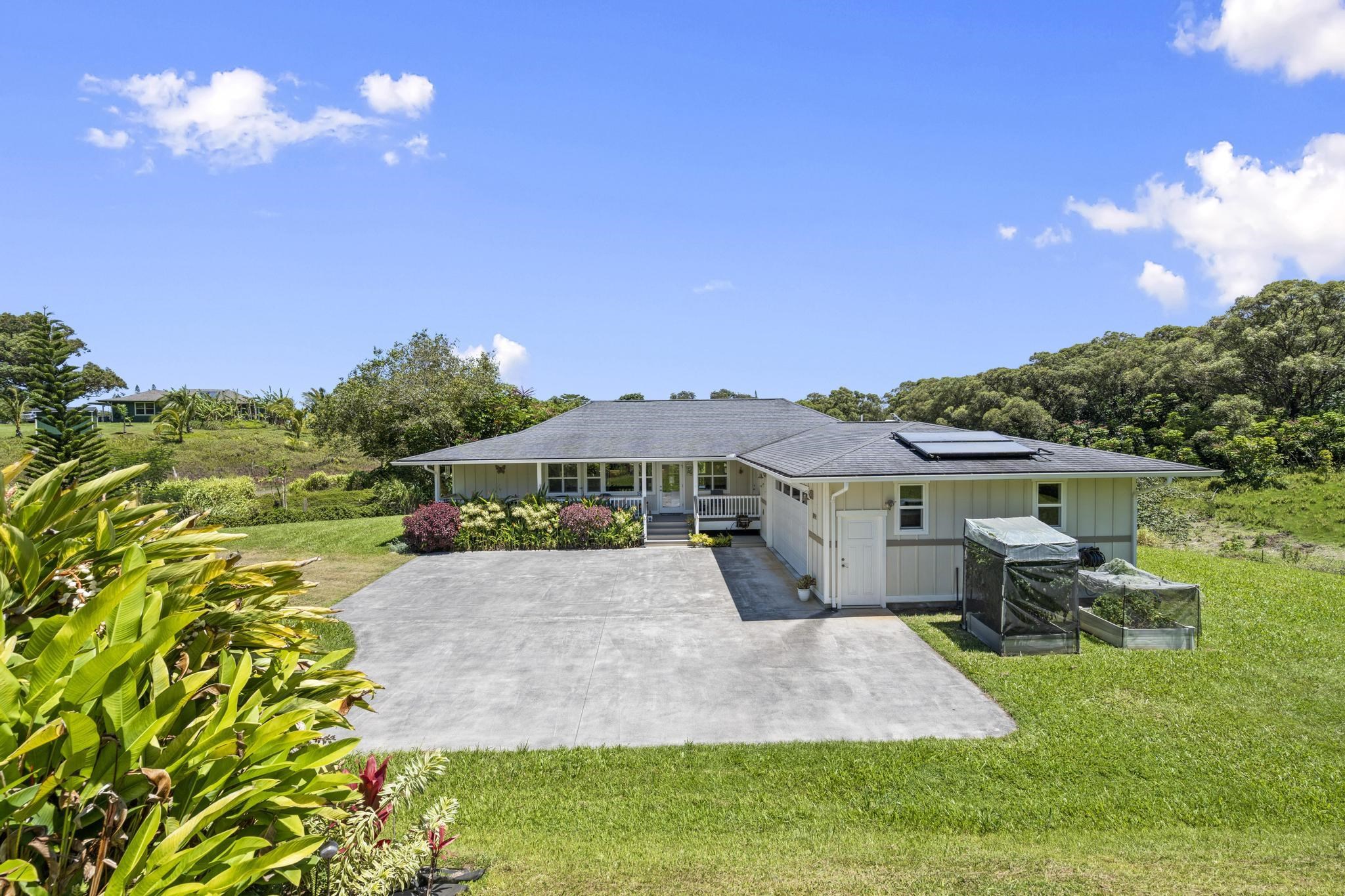 896 Hoomalolo Place, Unit B Haiku, HI 96708 - Photo 44 of 44 a front view of a house with a yard and garage