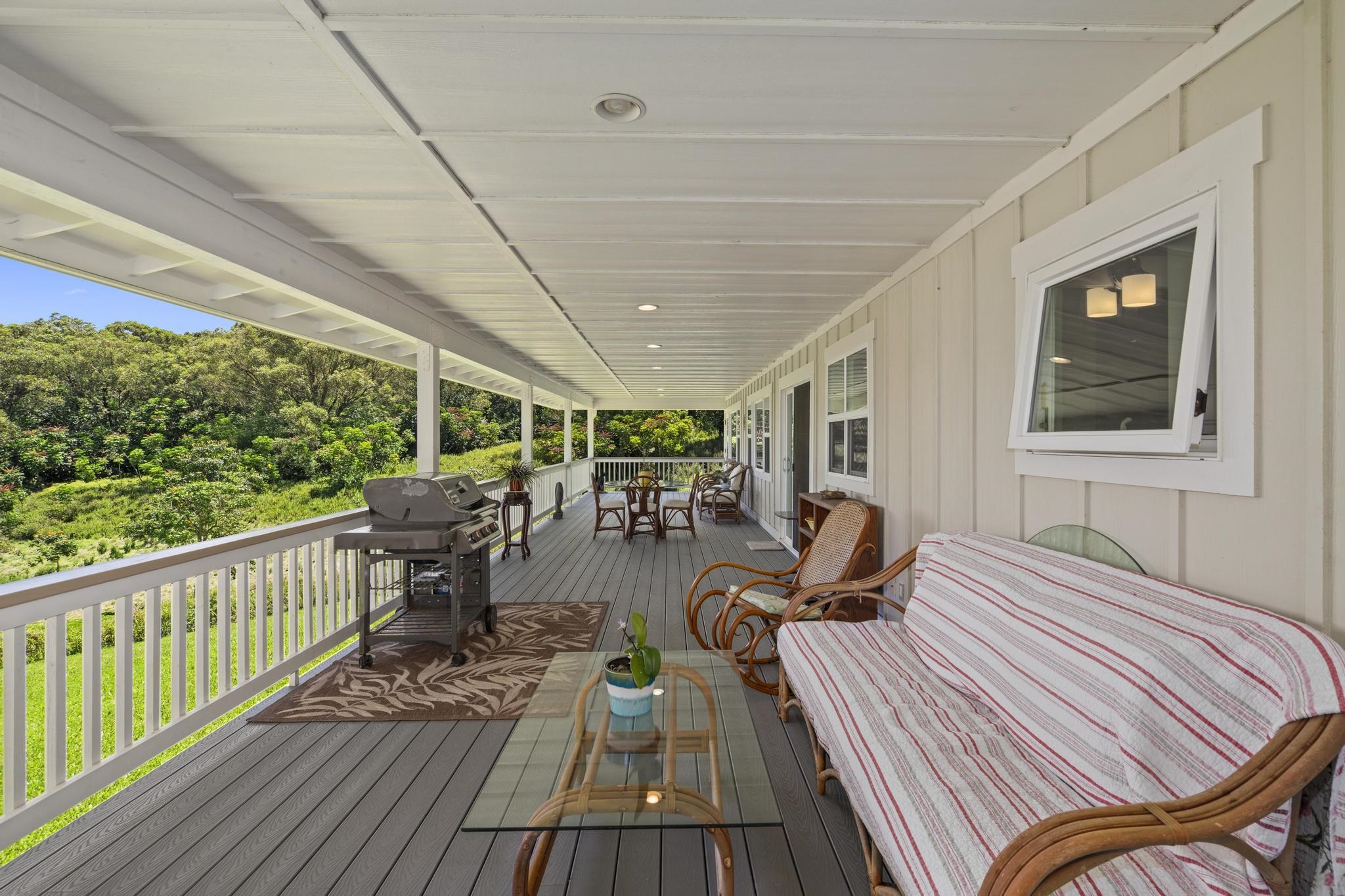 896 Hoomalolo Place, Unit B Haiku, HI 96708 - Photo 10 of 44 a view of a patio with table and chairs barbeque with wooden floor and fence