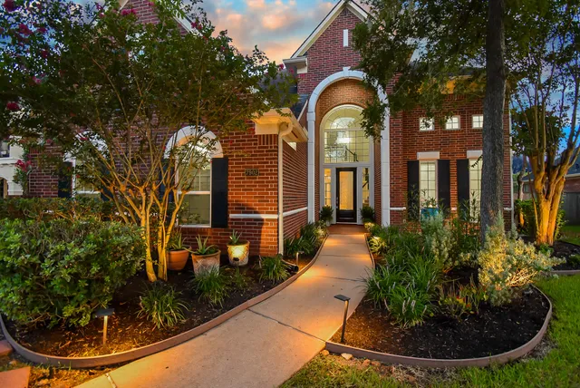 a view of a house with brick walls and flower plants