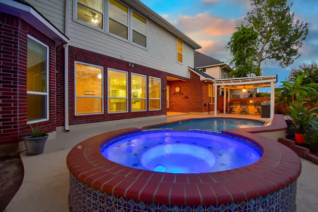 a view of a swimming pool with red chairs in a patio