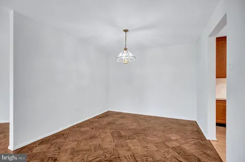 a view of empty room with wooden floor and ceiling fan