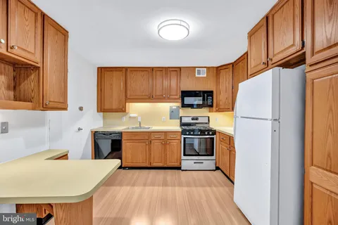 a kitchen with granite countertop a refrigerator stove top oven and sink
