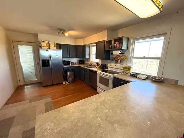 a kitchen with stainless steel appliances granite countertop a stove refrigerator and sink
