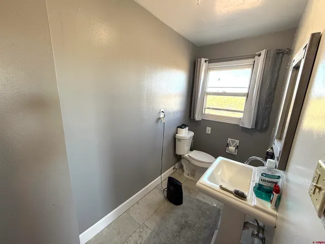a bathroom with a sink toilet and a mirror