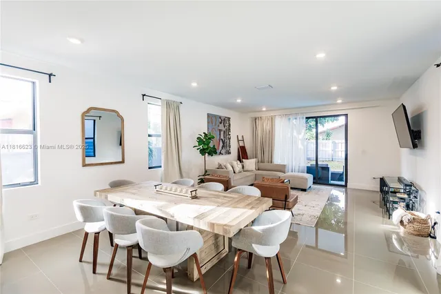 a living room with furniture flat screen tv and window