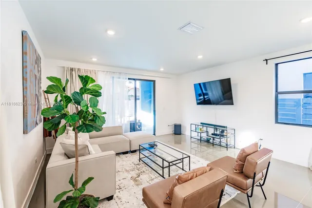 a living room with furniture a couch and a potted plant
