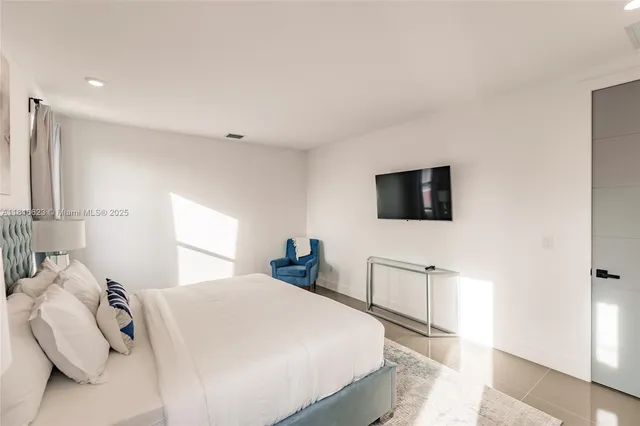 a bedroom with a bed and a flat screen tv